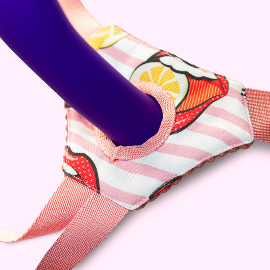 Base de strap on pour dildo compatible avec harnais Josephine. De couleur rose avec motifs funs et colorés.